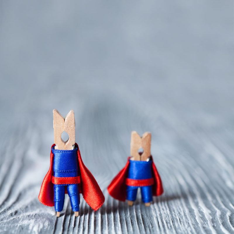 42156288 - clothespins super heroes in blue suit and red cape. big and small superman.