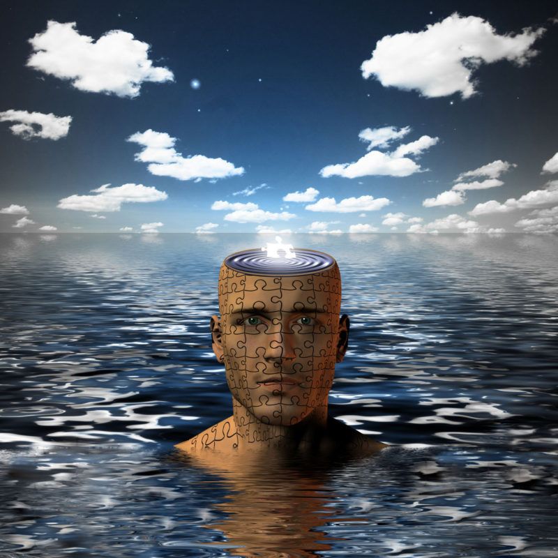 43588915 - man immersed in water with glowing puzzle piece in opened mind