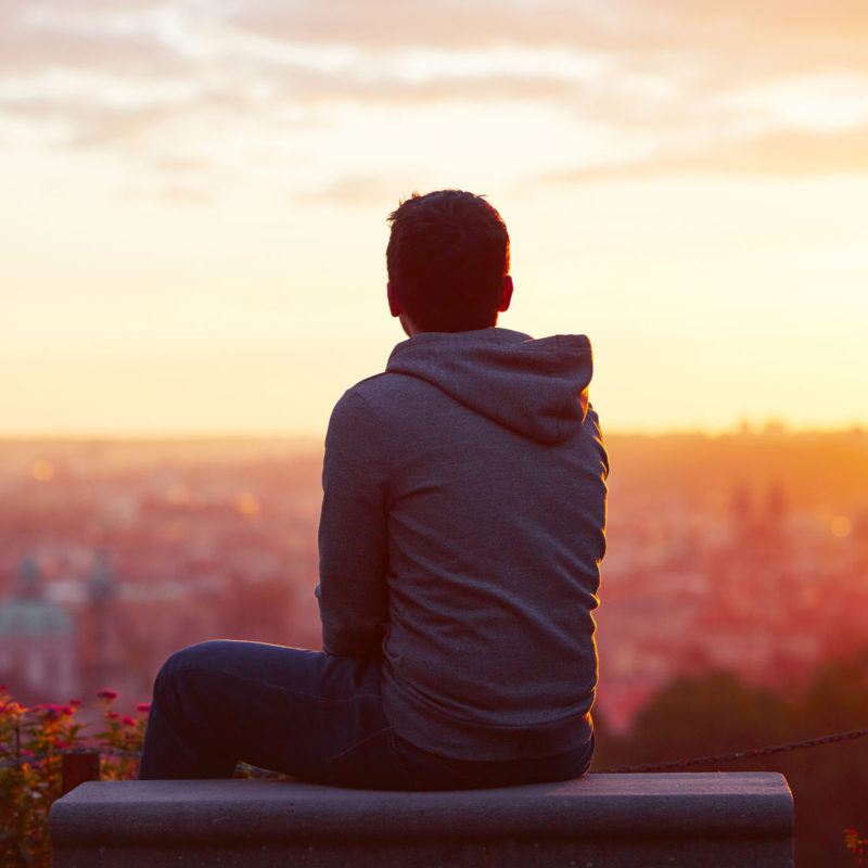 45779081 - young man is looking at the sunrise.