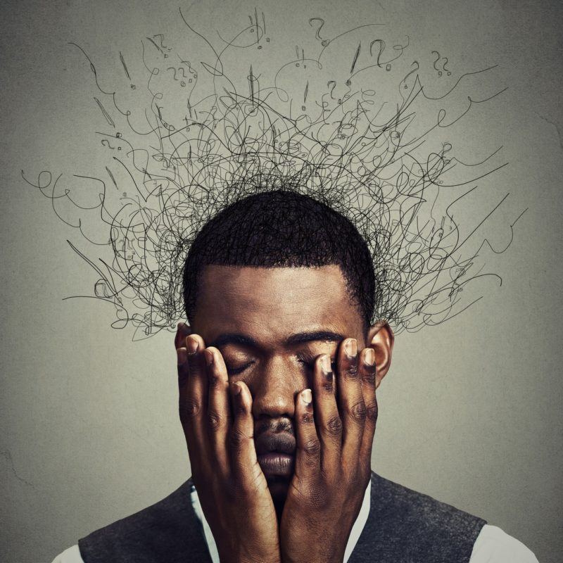 48484621 - depressed worried young man with worried desperate stressed expression hands covering face and brain melting into lines question marks. depression, anxiety disorders, life failure. gray background
