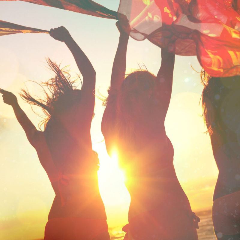 Happy women at sunset on the beach