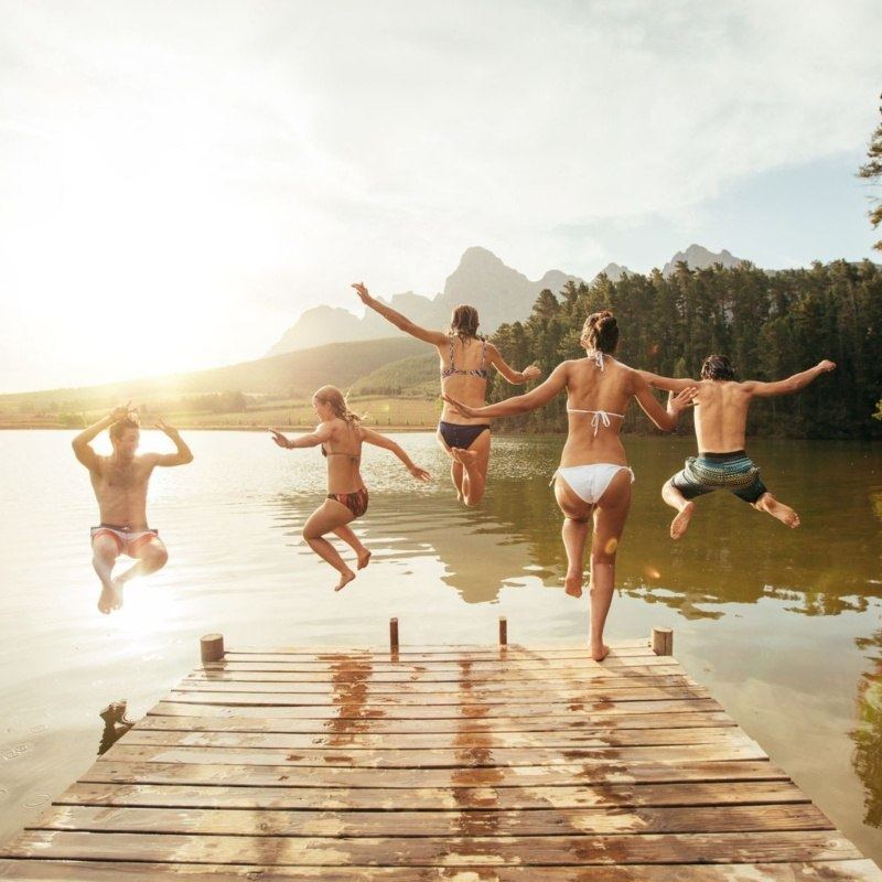 Happy people jumping in a lake