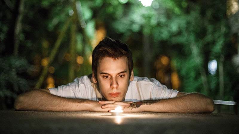 Man looking at candle listening to his intuition