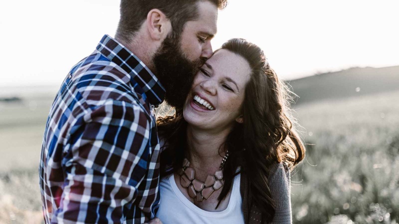 Couple in an authentic relationship hugging in a meadow