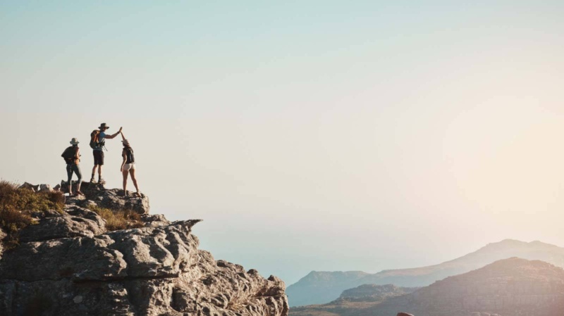 Group of friends on a mountaintop making new experiences