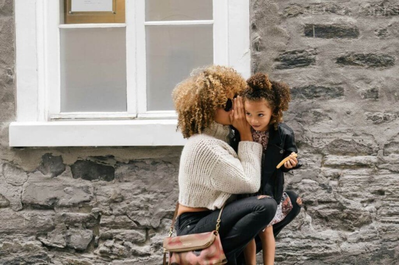 Mom whispering positive thoughts to her daughter