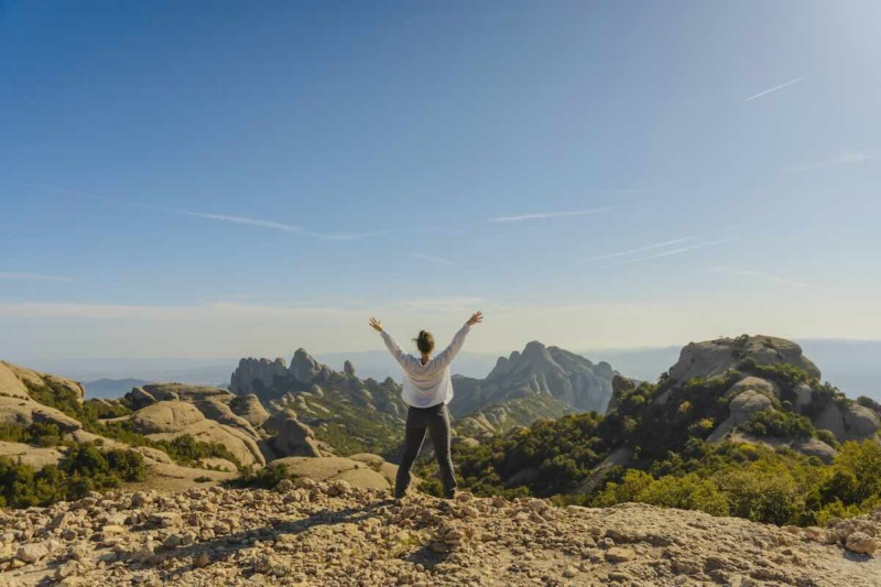 Woman on mountain top free from limiting beliefs